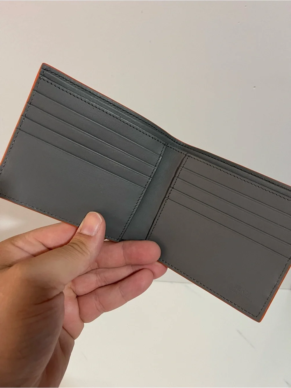 Fendi Gray Leather Embossed Face Bi-Fold Wallet with Orange Trim